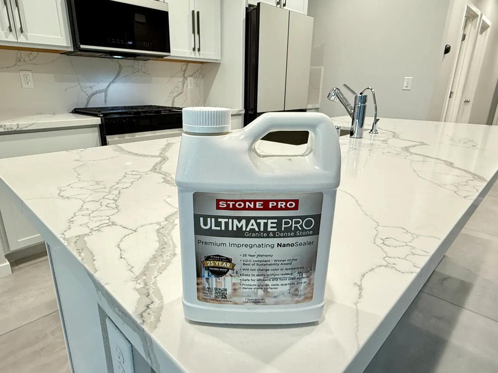 Impregnating stone sealer bottle resting on a newly sealed veined quartz countertop in a residential kitchen