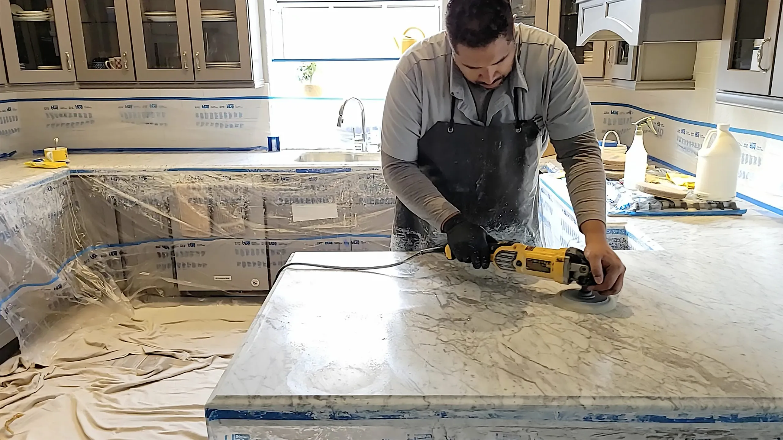 Polishing a marble kitchen island countertop with a diamond pad in a residential home