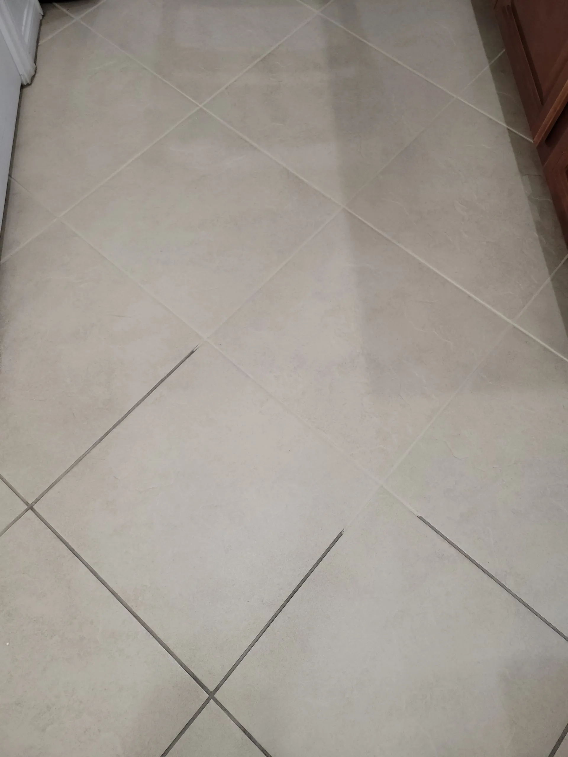 Diagonal cream tile floor fully restored after professional tile and grout cleaning in a residential kitchen