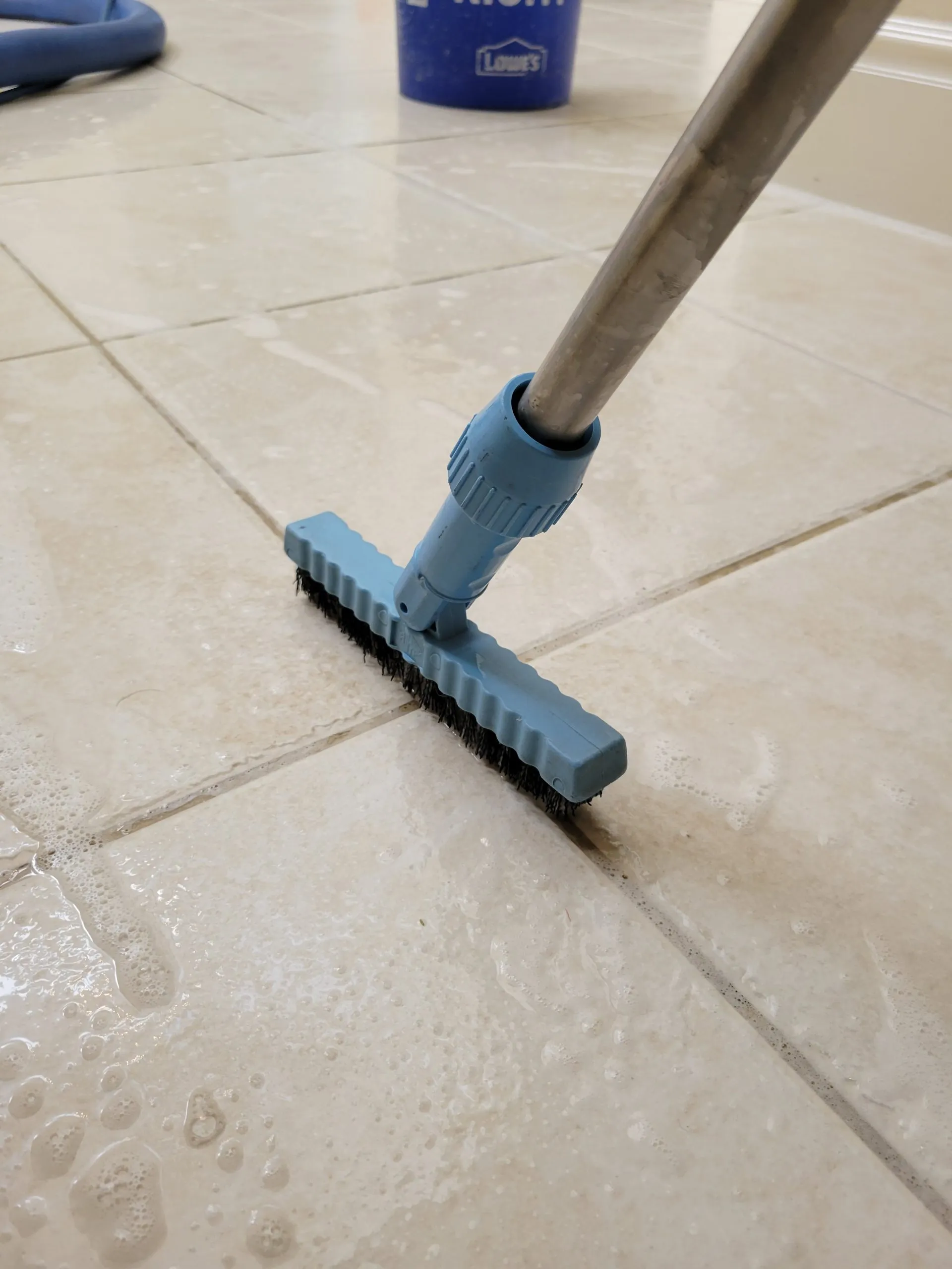 Manual grout scrubbing during a tile and grout cleaning service in a residential kitchen