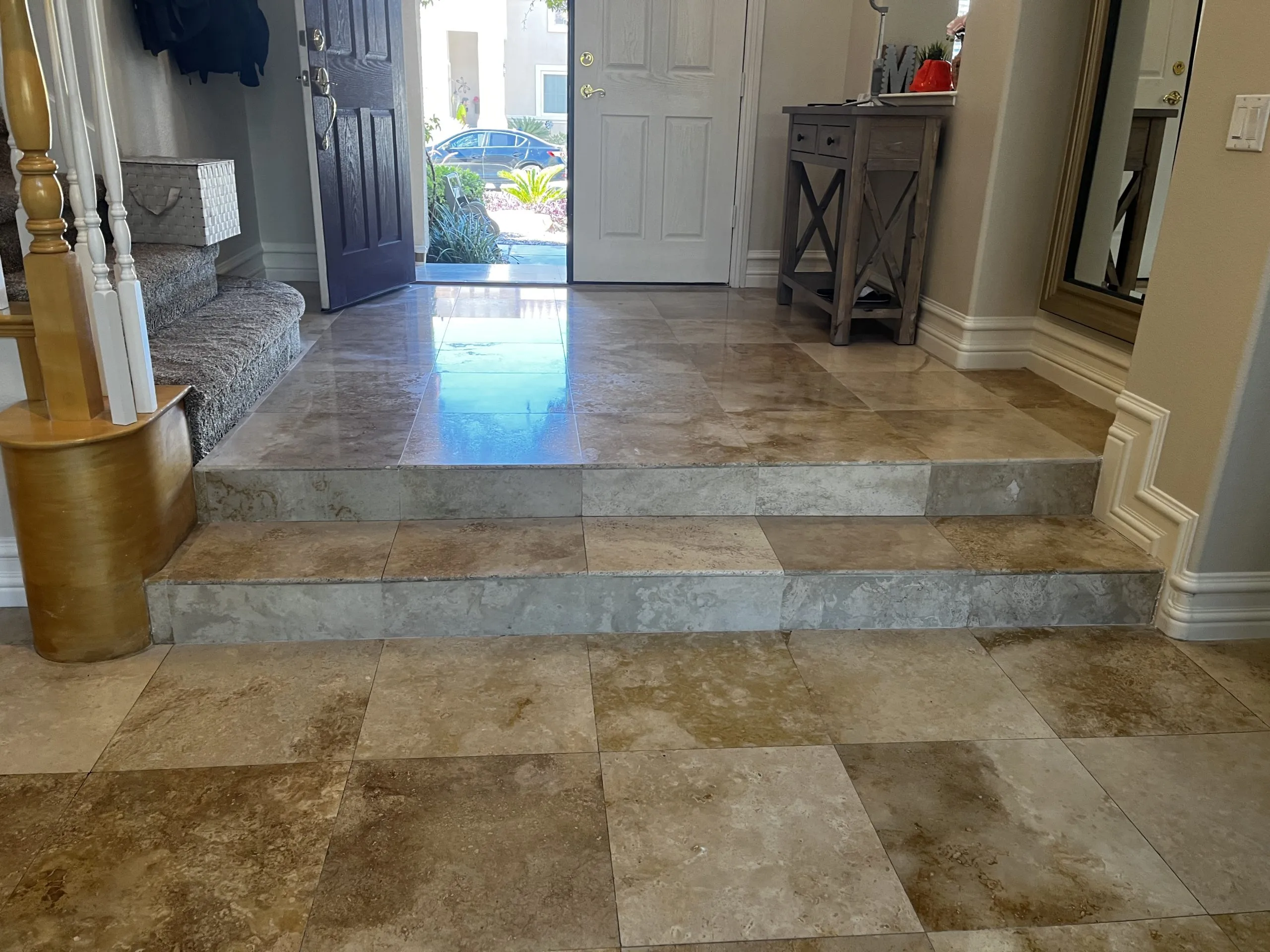 Restored travertine foyer with steps and front entry in a residential home