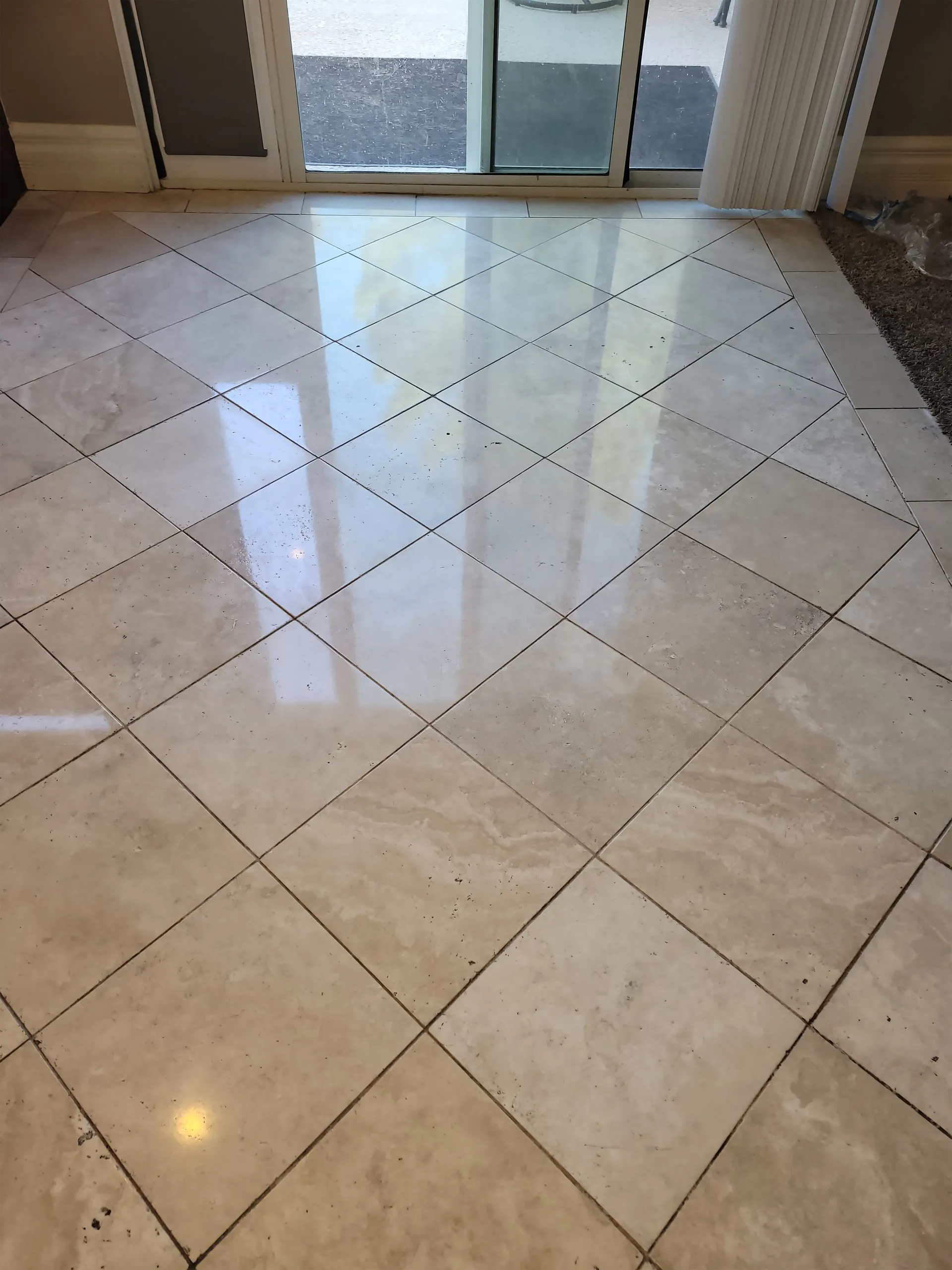 Polished travertine entryway with diamond pattern layout in a residential home